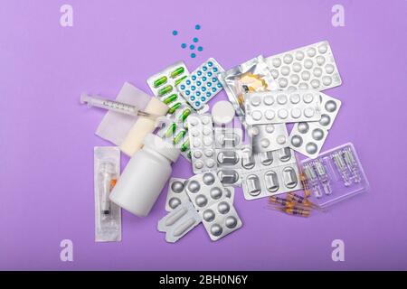 Different medicines on a lilac background. Colored and different types of medicine for different purposes. Doctor's prescription, each kind of medicin Stock Photo