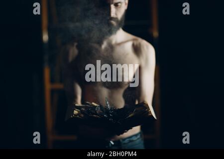 Man holds burning book in his hands. Stock Photo