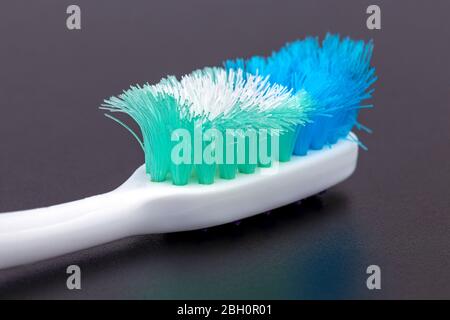 Old unusable worn-out and must change close up toothbrush on black background Stock Photo