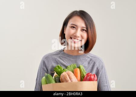 Young woman with a grocery shopping bag. Isolated on white background. Stock Photo