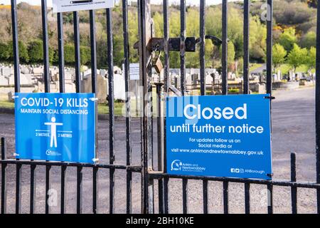 Northern Ireland, UK. 24 April 2020 - Sign outside a cemetery advising the public that it is closed due to Covid-19.   Health Minister Robin Swann is under public and legal pressure to reopen cemeteries in Northern Ireland which have been forced to close to visitors, with the exception of funerals, due to Covid-19.  Relatives are upset that they are unable to visit graves of recently deceased people. Credit: Stephen Barnes/Alamy Live News Stock Photo