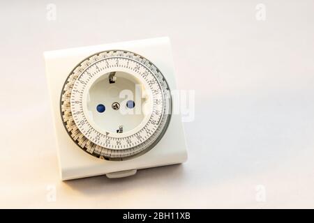 Analogue timer switch to set your light on or machine on a certain moment on a white background Stock Photo
