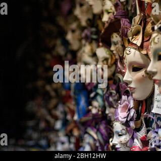 Traditional Venetian Carnival masks are arrayed on the wall of a shop in Venice, Italy Stock Photo