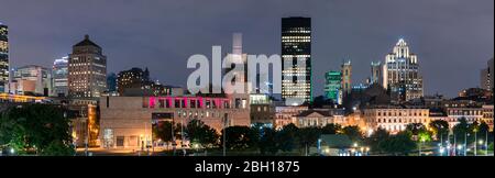 Long exposure shot of downtown Montreal with its modern building and the Notre-Dame Basilica illuminated at night, Quebec, Canada Stock Photo