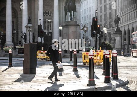 London, UK. 23rd Apr 2020. A lone commuter makes his way across The Royal Exchange at Bank early this morning in the City of London, as lockdown measures need to be eased out in the next three to four weeks amid coronavirus for the economy to recover. City of London lockdown, England, United Kingdom 23rd April, 2020 Credit: Jeff Gilbert/Alamy Live News Stock Photo