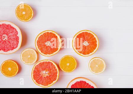 Halves of fresh orange and grapefruit citrus fruits on white wooden background Stock Photo