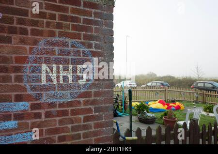 Chalk writing on a house wall in England about NHS Stay Safe Coronavirus Covid-19 Stock Photo