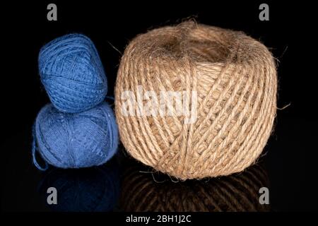 Group of three whole thread spools isolated on black glass Stock Photo