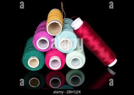 Lot of whole thread spool isolated on black glass Stock Photo