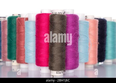 Lot of whole colourful thread spools isolated on white Stock Photo