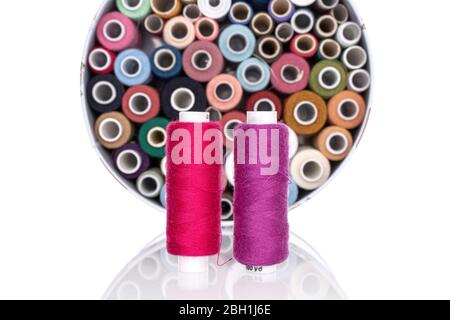 Lot of whole colourful thread spools two in front isolated on white Stock Photo