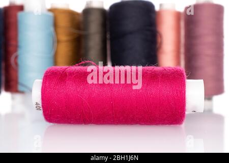 Lot of whole thread spools pink in front isolated on white Stock Photo