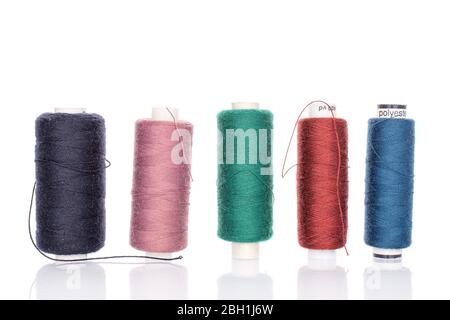 Group of five whole thread spools in row isolated on white Stock Photo