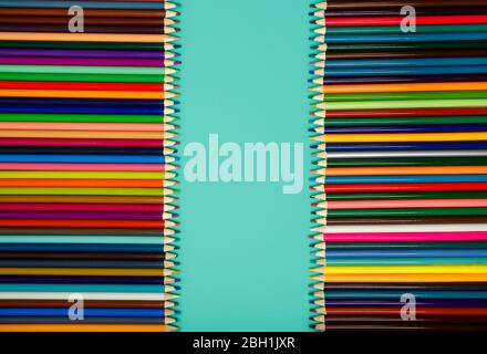 Colored pencils of all colors of the rainbow on blue background Stock Photo