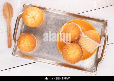 Group of five whole small baked muffin on tray on white wood Stock Photo