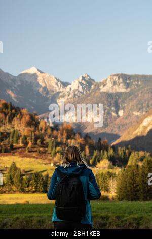 Hiking young woman with alps mountains on background. Stock Photo