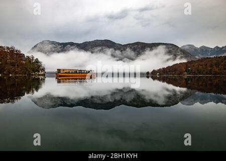 lake with boat in valley in Slovenian Alps. Bohinj Stock Photo