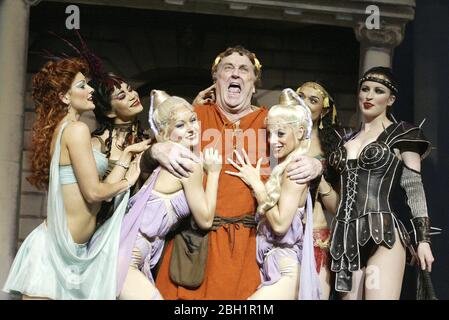 Desmond Barrit (Prologus) with courtesans in A FUNNY THING HAPPENED ON THE WAY TO THE FORUM at the National Theatre, London in 2004  book: Burt Shevelove & Larry Gelbart  music & lyrics: Stephen Sondheim  director: Edward Hall Stock Photo