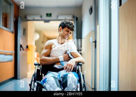 Young man sitting in wheel chair in hospital Stock Photo