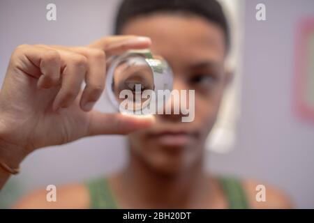 Close up shot of young boy looking through a crystal ball