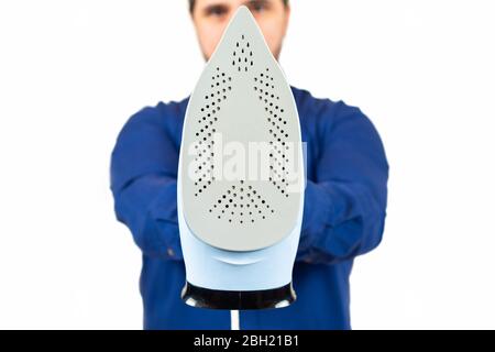 man in a blue shirt holding an iron on white background Stock Photo