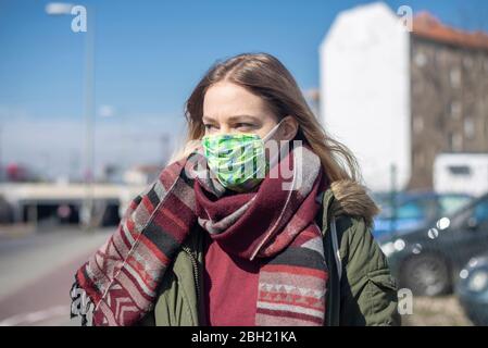 Portrait of young woman wearing mask in the city Stock Photo