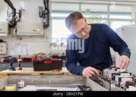 Electrician working on circuitry in workshop Stock Photo
