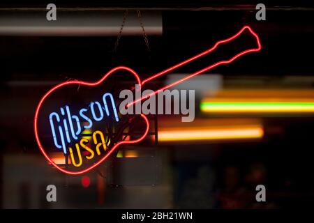 Close-up on a neon light shaped into a guitar with written inside "Gibson USA". Stock Photo