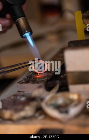 Goldsmith working with bunsen burner on ring Stock Photo