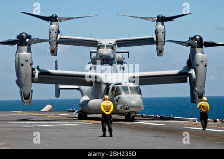 U.S. Navy MV-22B Osprey tiltrotor aircraft with Marine Medium Tiltrotor Squadron 265 lands on the flight deck of Flagship America-class amphibious assault ship USS America during flight operations April 20, 2020 in the South China Sea.