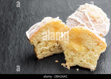 Halved  lemon cupcakes on black stone background Stock Photo