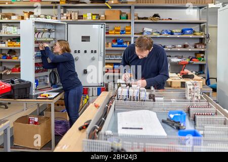 Two electricians working in workshop Stock Photo