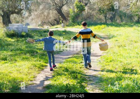Mother and daughter walking hand in hand on a rural path Stock Photo