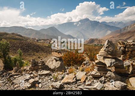 Himalayan landscape, cairns on background of mountain ranges and village of Ranipauwa. View from Muktinath Monastery, Lower Mustang, Nepal Stock Photo