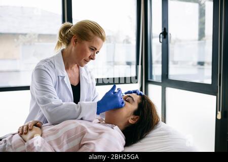Woman receiving botox injection in medical practice Stock Photo