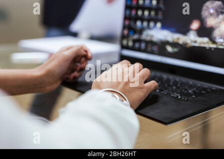Close-up of businesswoman at desk using laptop Stock Photo