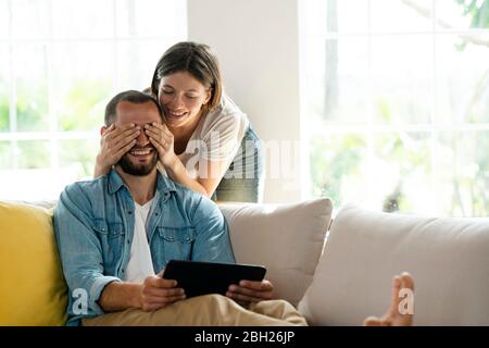 Young couple at home having fun on couch Stock Photo
