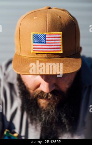 Bearded man wearing baseball cap with American flag, close-up Stock Photo