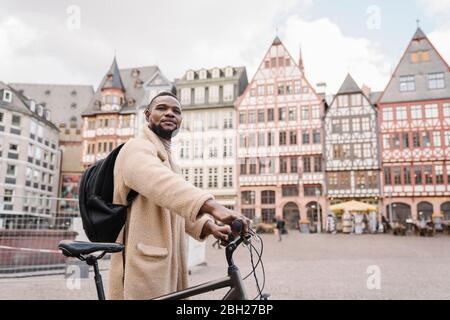 Portrait of stylish man with a bicycle in old town, Frankfurt, Germany Stock Photo