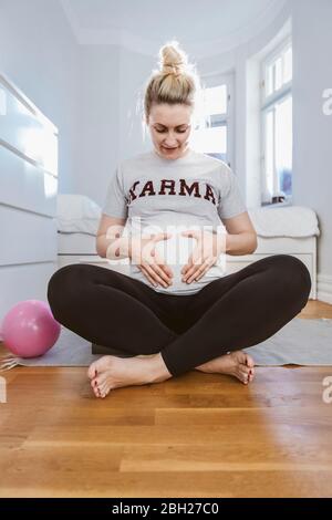 Pregnant woman practising with a ball at home Stock Photo