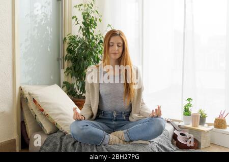 Young woman practicing yoga at home Stock Photo