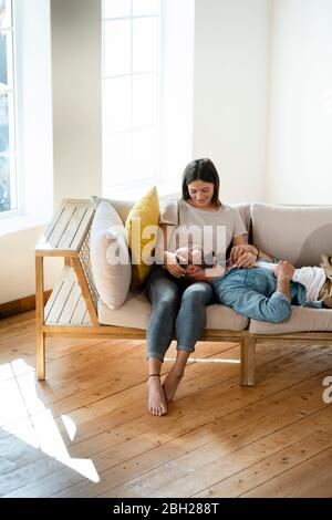 Affectionate young couple in love relaxing on couch at home Stock Photo