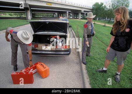 Austin Texas USA: Hispanic male and Anglo female Department of Public Safety officers arrest Anglo male driver after finding stolen goods in his car. ©Bob Daemmrich Stock Photo