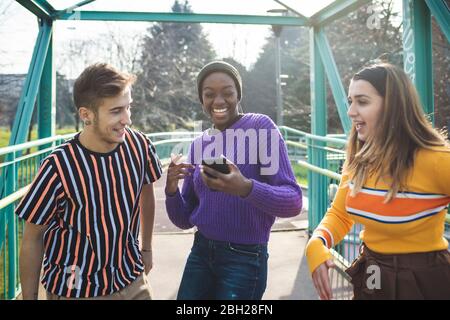 Friends having fun in a skate park, using smartphone Stock Photo