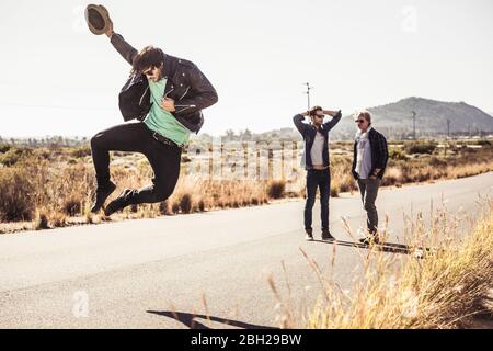 Three men on a road in the countryside Stock Photo