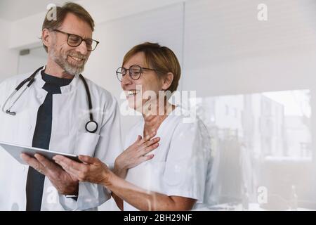 Happy doctor and assistant using tablet in medical practice Stock Photo