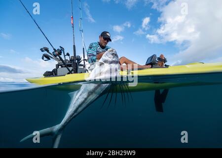 Split shot of man in a kayak catching a fish Stock Photo