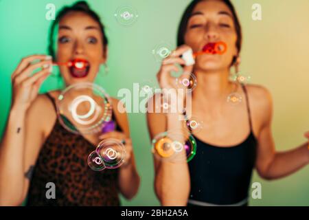 Two friends blowing soap bubbles Stock Photo