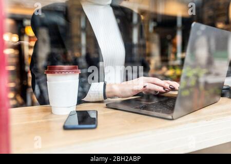 Close-up of businesswoman using laptop at a cafe in the city Stock Photo