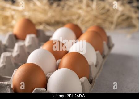 Brown and white chicken eggs in a close-up package. Straw in the background Stock Photo